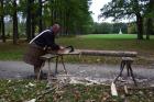 Účastník kurzu si zkouší sekerou opracovat dřevo. 